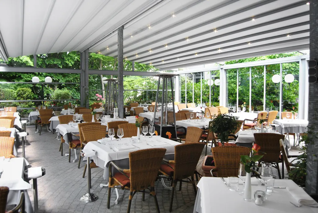 Überdachter Wintergarten mit Korbsesseln