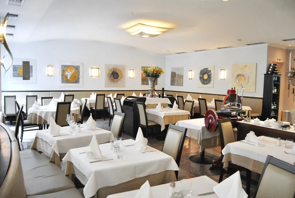 Heller Gastraum des Ristorante Cortile mit eingedeckten Tischen