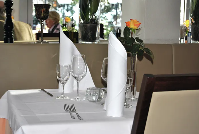 Eingedeckter Tisch mit Weingläsern und frischer Rose